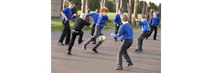 Boys playing football in the playground